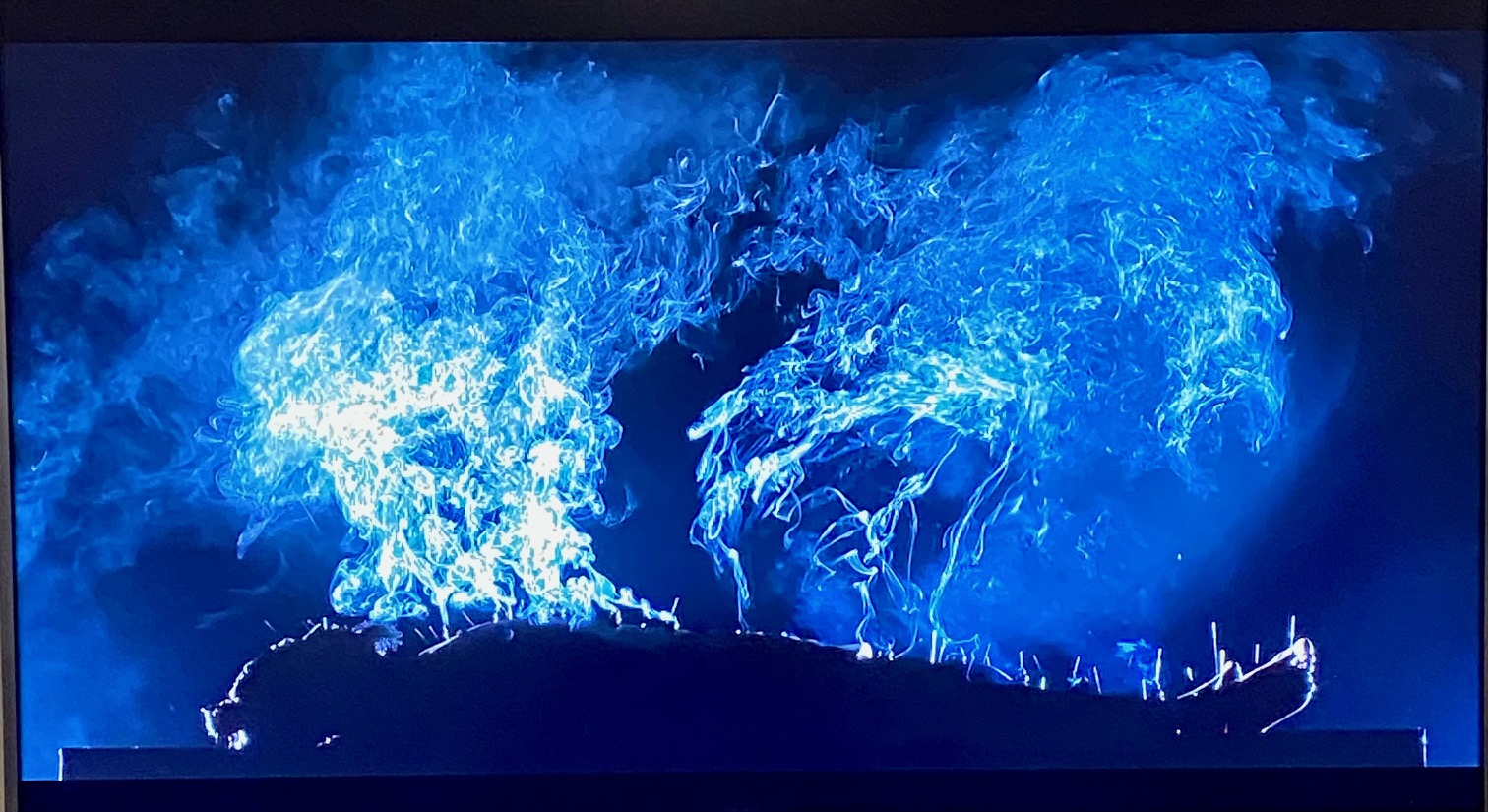 Screenshot from a film, body lying on a table, covered in acupuncture needles and moxibustion nodes.